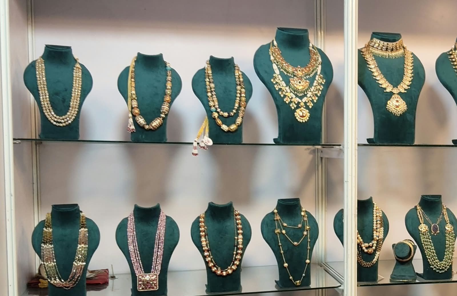 A glass display case of hand-strung gold bead necklaces at the Jewels By Sireesha studio